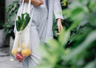 a woman with a bag in which there are vegetables